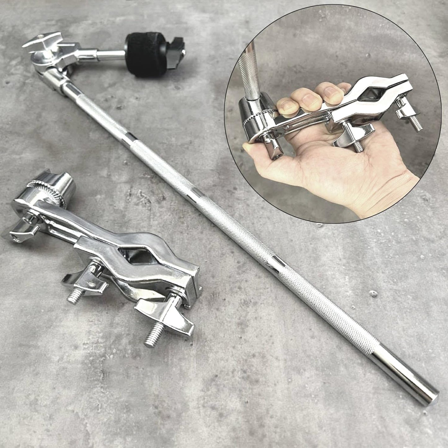 Metal drum stand with clamps on a concrete surface, with a close-up of a hand holding one clamp.