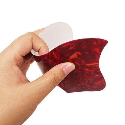 Hand holding a red and white object with a marbled pattern on a white background