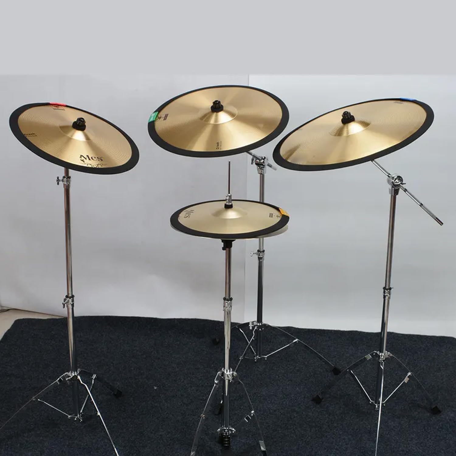 Set of cymbals on stands against a plain background