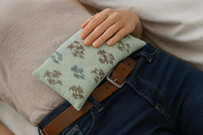 Person holding a patterned hot water bottle against their body