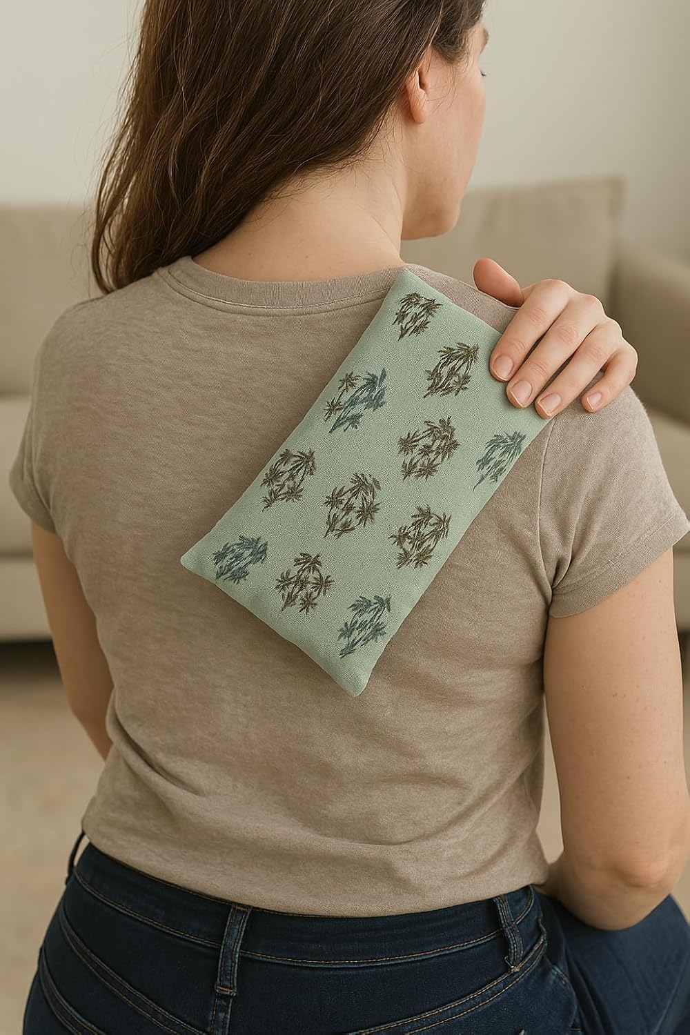 Person holding a green patterned heat pack against their shoulder
