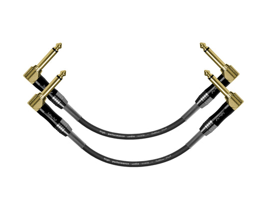Black guitar cable with gold connectors on a white background