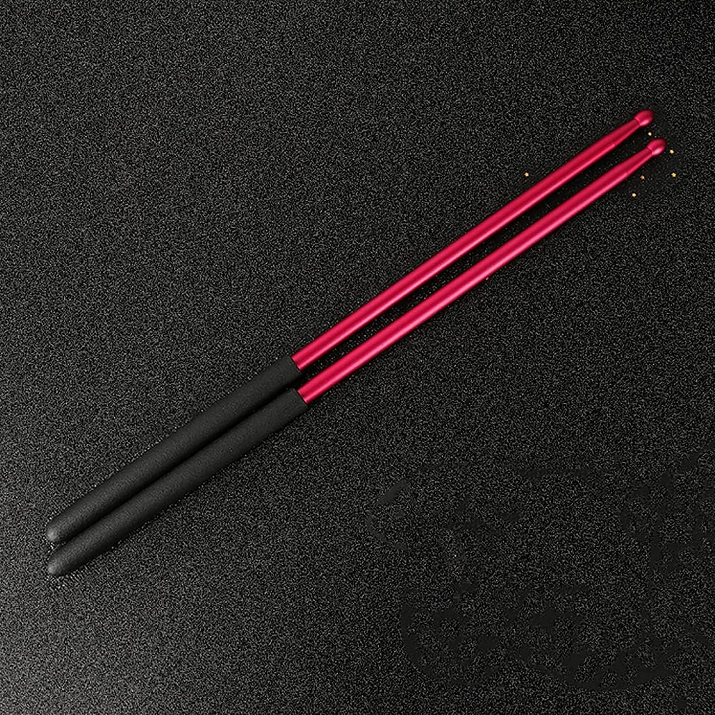 Black and pink drumsticks on a black background